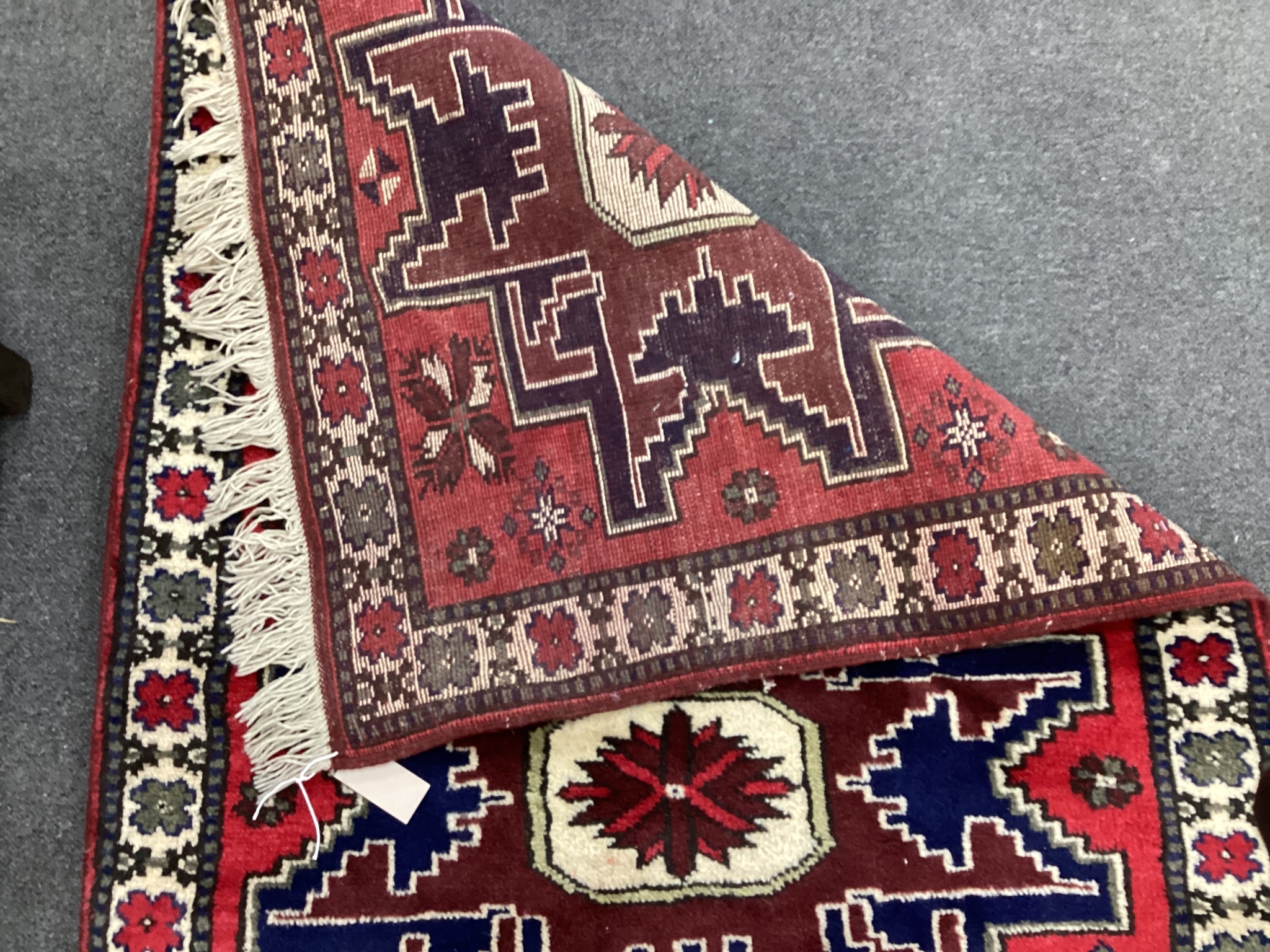 A Caucasian style red ground rug, 180 x 94cm